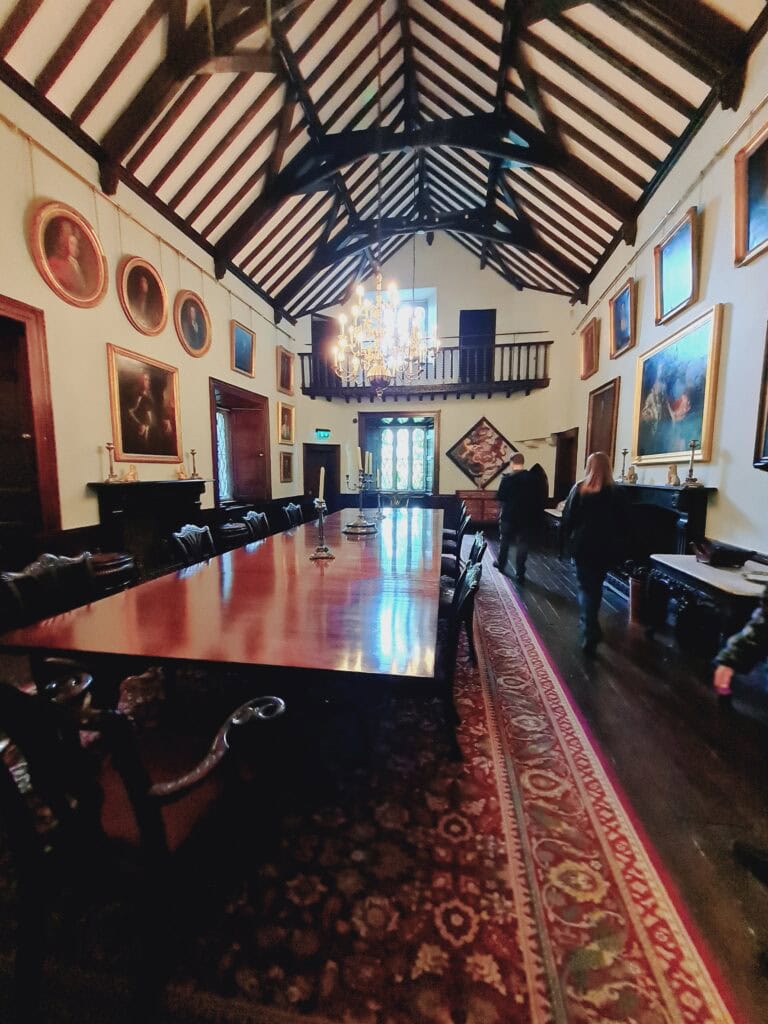 Interior del castillo de Malahide de Dublin. Cuadros colgados y turistas mirando