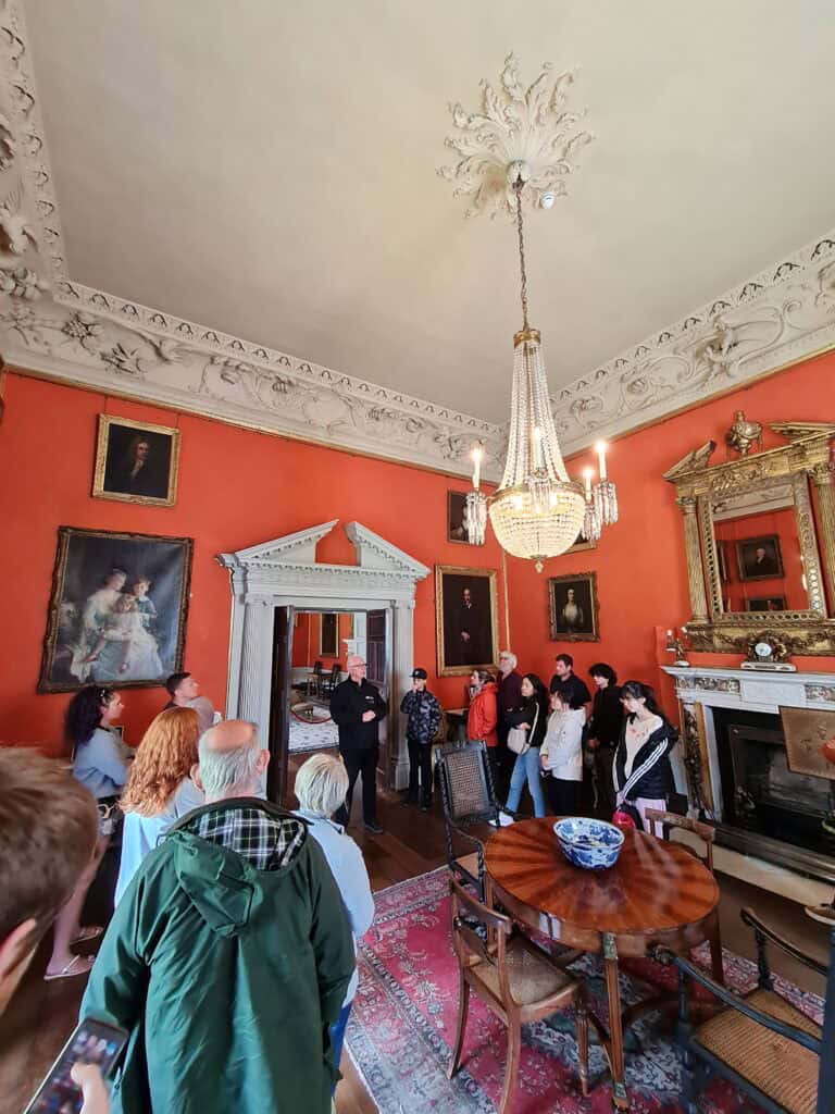 Interior del castillo de Malahide de Dublin. Cuadros colgados y turistas mirando