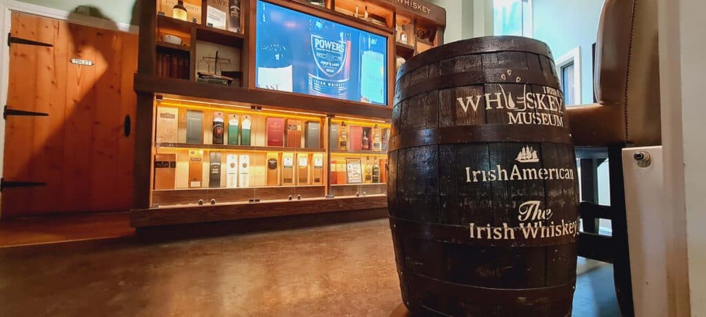 Interior del Irish Whiskey Museum en Dublín, con botellas expuestas y carteles explicativos.